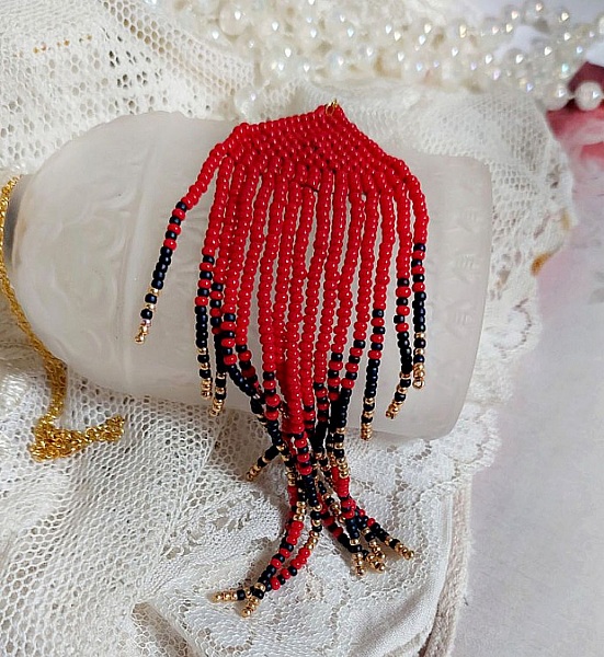 Pendentif Tourbillons de Rouge avec des rocailles aux trois couleurs : Rouge, Bleu Iris et Dor&eacute; pour les pampilles. Le tout est mont&eacute; sur une cha&icirc;ne et un mousqueton en Plaqu&eacute; Or