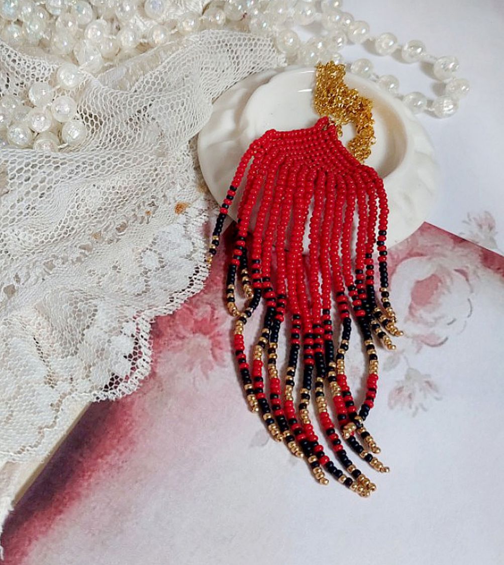 Pendentif Tourbillons de Rouge avec des rocailles aux trois couleurs : Rouge, Bleu Iris et Dor&eacute; pour les pampilles. Le tout est mont&eacute; sur une cha&icirc;ne et un mousqueton en Plaqu&eacute; Or