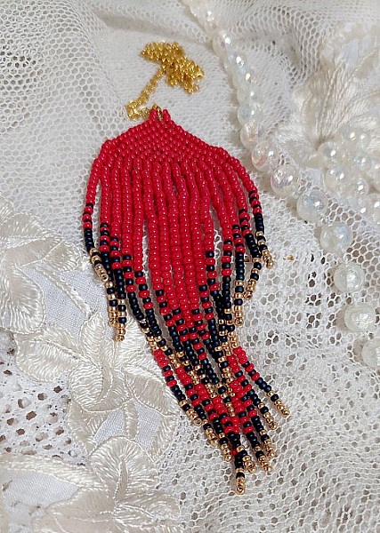 Pendentif Tourbillons de Rouge avec des rocailles aux trois couleurs : Rouge, Bleu Iris et Dor&eacute; pour les pampilles. Le tout est mont&eacute; sur une cha&icirc;ne et un mousqueton en Plaqu&eacute; Or