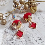BO Passionn&eacute;ment mont&eacute;es avec des pompons Rouges tr&egrave;s tendances &agrave; laquelle s&rsquo;ajoute des coupelles en forme d&rsquo;arabesque, pendentifs vitrail Rouge/Dor&eacute; et cabochons en Cristal AB sur crochets en Laiton