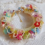 Bracelet Garden Flowers perl&eacute; avec des rocailles Jaunes et Ivoires &agrave; laquelle s'ajoute des fleurs et feuilles Lucites, cristaux, perles, tubes et fermoir en plaqu&eacute; Or, une belle Nature !