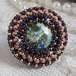 Bague Bonjour Paris cabochon marbr&eacute; bleu/vert/&eacute;cru orn&eacute;e de rocailles Miyuki dont la couleur dominante est le Violet. Mont&eacute;s sur bague dor&eacute;e en laiton et sur une feutrine Bleu n&eacute;on. Un look city !
