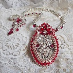 Collier Drigon Red brod&eacute; avec des navettes et cabochons aux couleurs Rouge, Cristal et Argent&eacute;, repr&eacute;sentant une femme Dragon, strass, rocailles, facettes, cha&icirc;nettes et fermoirs en argent 925/1000
