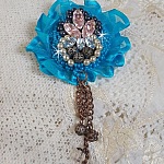 Broche Belle Epoque Haute-Couture est brod&eacute;e avec des Cristaux de Swarovski, des perles rondes nacr&eacute;es, des breloques, un ruban et des rocailles