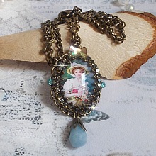 Pendentif Douce Dame cr&eacute;&eacute; avec un cabochon repr&eacute;sentant une femme au chapeau blanc orn&eacute; de cristaux, des accessoires de couleur Bronze et un jade teint&eacute; bleu 