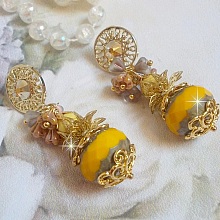 BO Lumi&egrave;re Opale Jaune avec des perles potirons jaunes &agrave; laquelle s&rsquo;ajoute des fleurs, cabochons en cristal, coupelles et perles rondes. Mont&eacute;s sur clous d&rsquo;oreilles en M&eacute;tal. Un style moderne