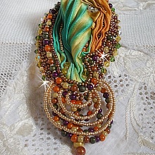 Broche Lune V&eacute;nitienne brod&eacute;e avec un ruban de soie orange, vert et jaune, cristaux, : toupies et chatons. S&rsquo;ajoute &agrave; l&rsquo;ensemble des perles magiques et rocailles sur une broche Dor&eacute; 
