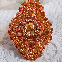 Bague Rumba brod&eacute;e avec un cabochon en Cristal de Swarovski Sunshine orn&eacute;e de facettes Cristal Jaune/Orange et Abricot &agrave; laquelle s'ajoute des chatons, rocailles Oranges et Dor&eacute;es sur bague Dor&eacute;e