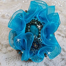 Bague Ilycia Charming brod&eacute;e avec un cabochon facett&eacute; Bleu Turquoise, fleur en Cristal, chatons, rocailles Gold et Bronze. Le tout est mont&eacute; sur un support de bague couleur Or en laiton