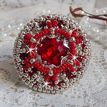 Bague Drigon Red brod&eacute;e avec un cabochon carr&eacute; Rouge sur une estampe Argent&eacute;e. Orn&eacute;e de chatons en Cristal puis model&eacute;e avec des rocailles et perles. Le tout est mont&eacute; sur une bague r&eacute;glable argent&eacute;e 