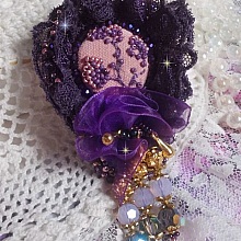 Broche Lady Romantique brod&eacute;e avec une dentelle violine ann&eacute;e 1950 avec un tissu en lin vieux rose brod&eacute; de fleurs et branches en rocailles bord&eacute; d&rsquo;un ruban organza, fleurs, cristaux et breloques