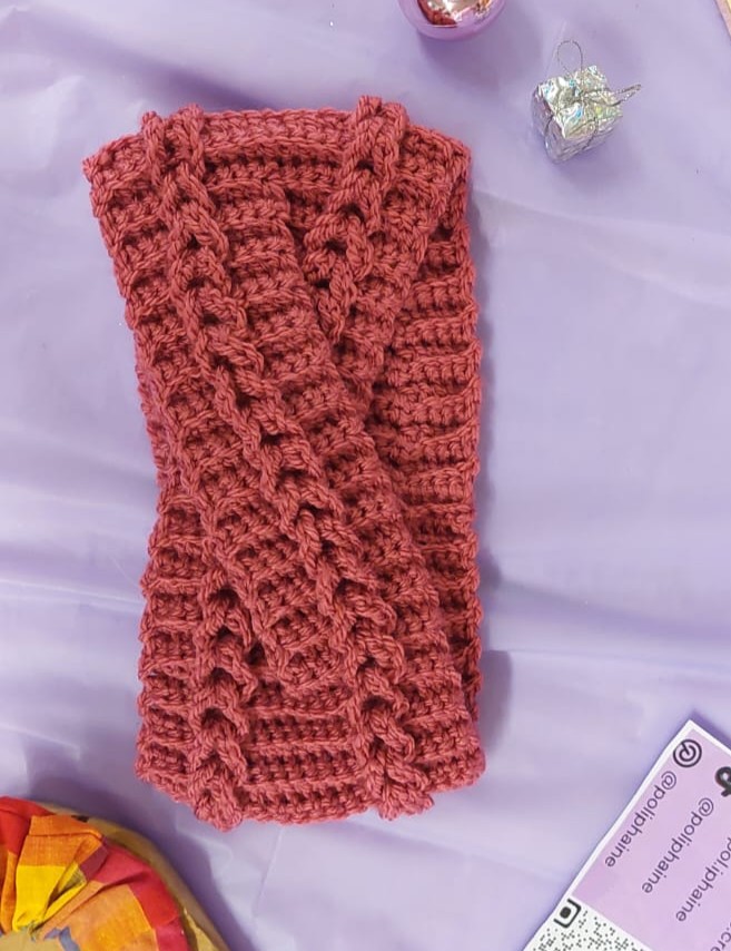 Bandeau torsadé en laine rose réalisé au crochet pour l'hiver.
