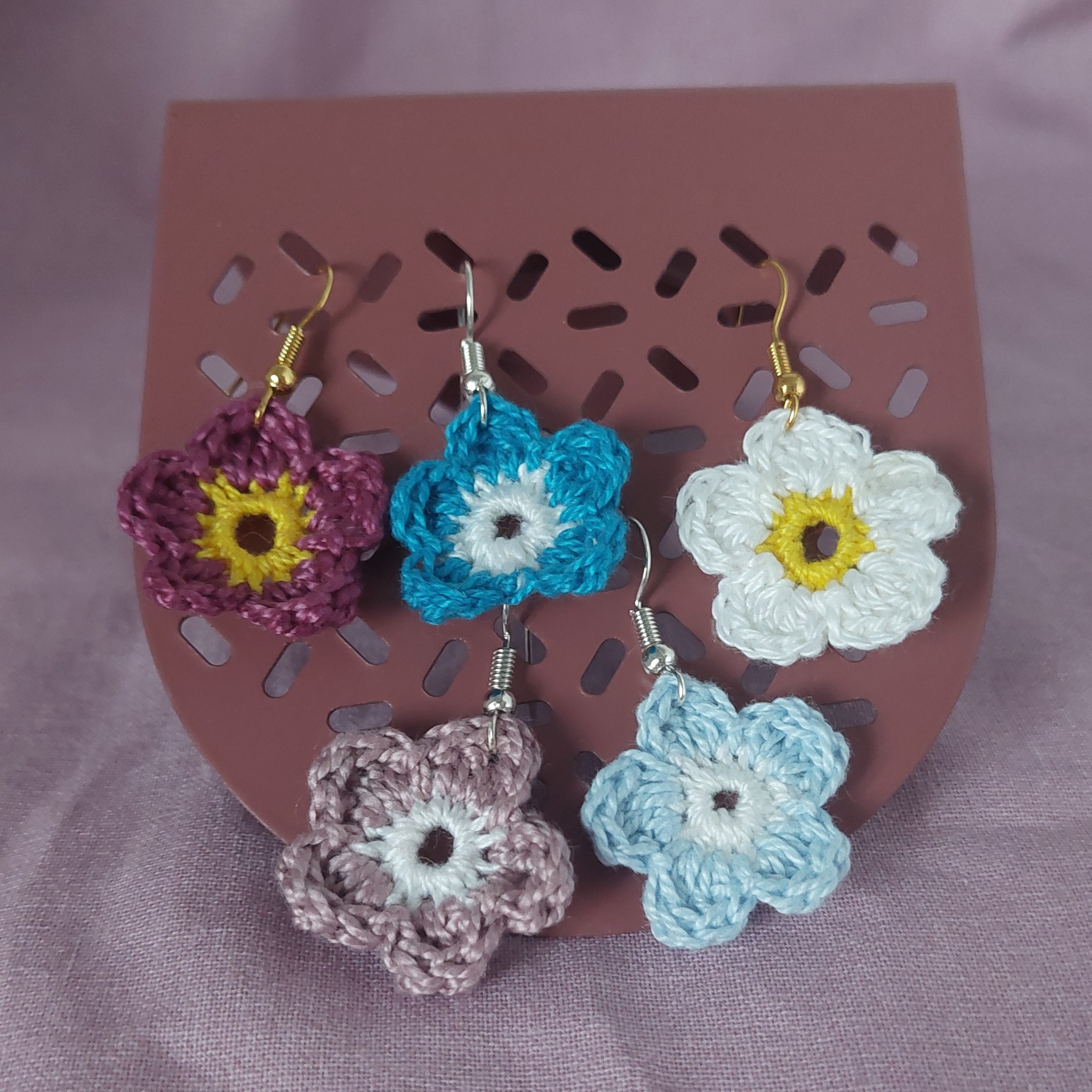 Boucles d'oreilles en forme de fleurs réalisées au crochet.