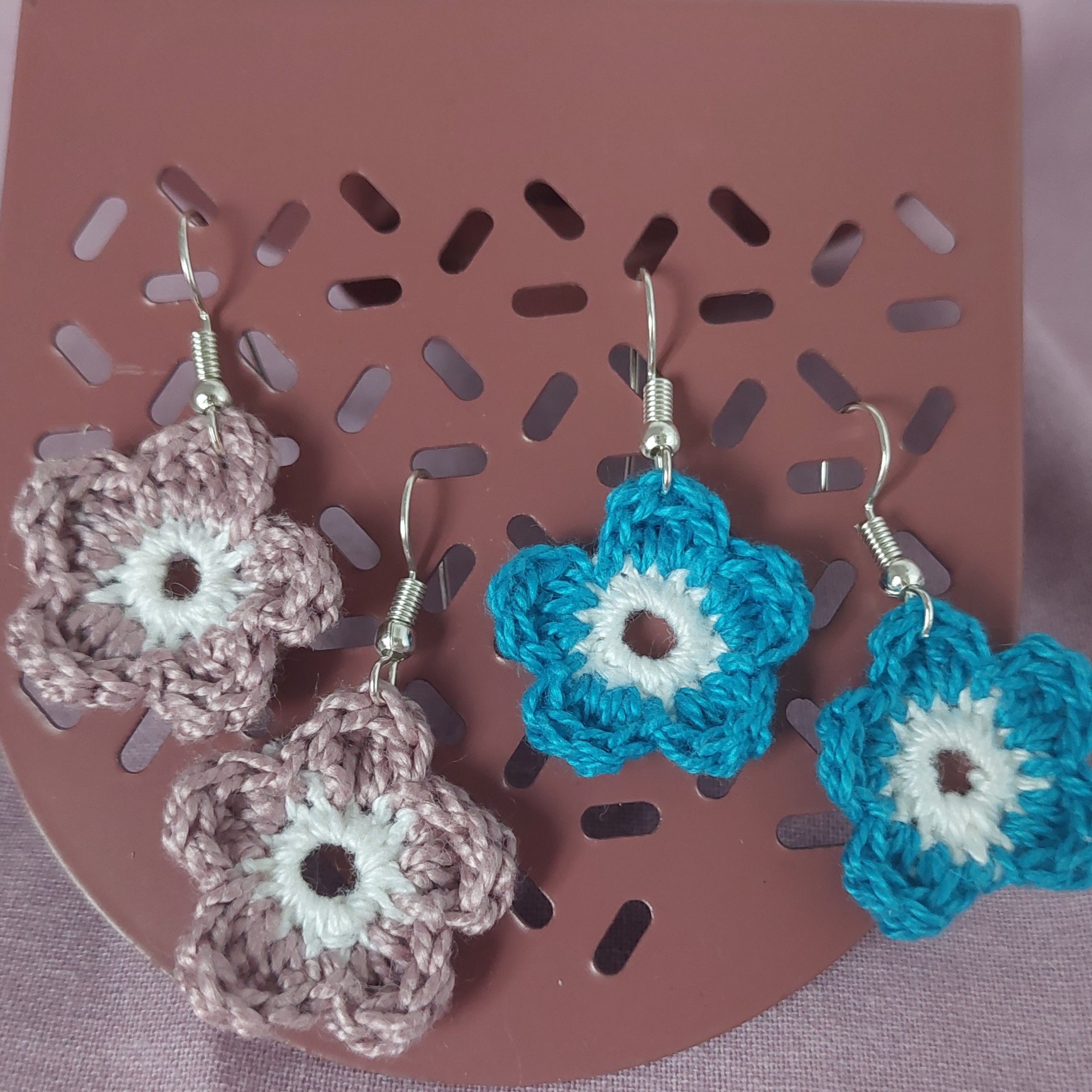 Boucles d'oreilles en forme de fleurs réalisées au crochet.